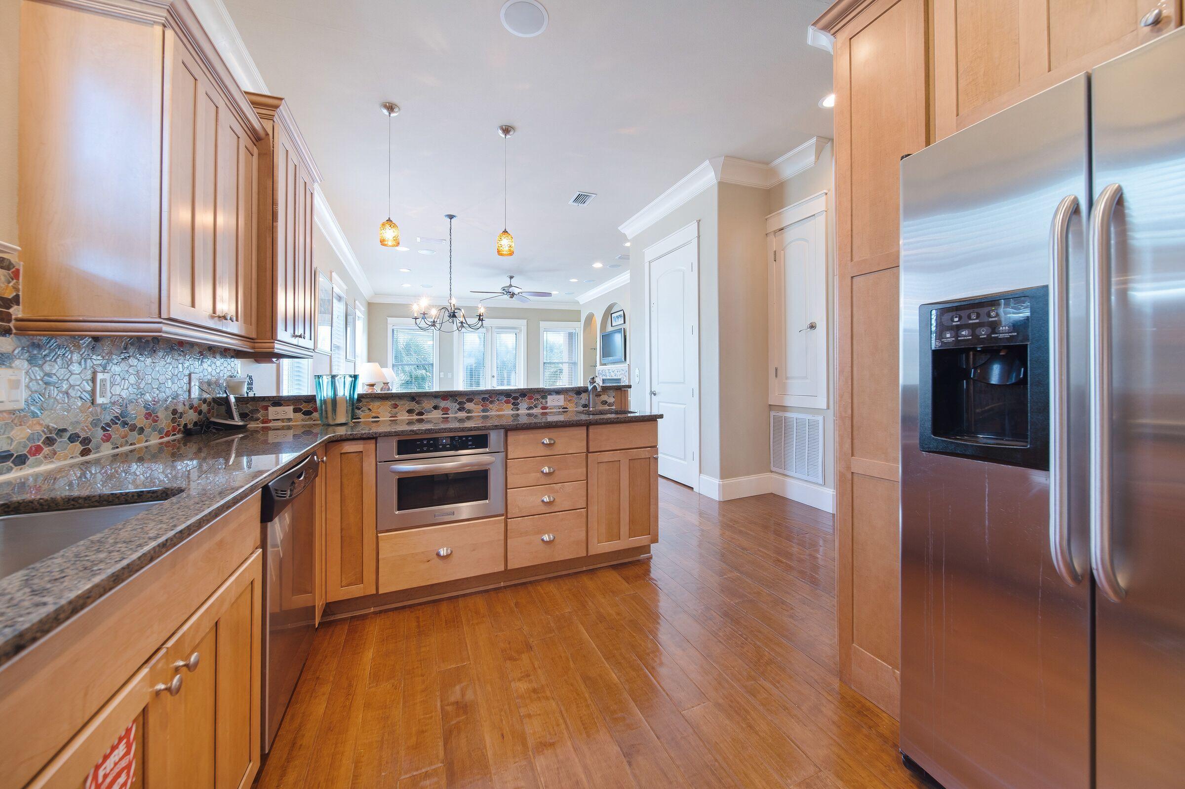 4836 Ocean Boulevard Destin, FL 32541 - Photo 16 of 71 a kitchen with stainless steel appliances white cabinets and wooden floors