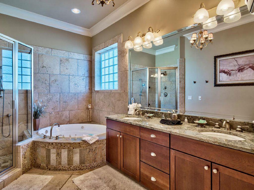4836 Ocean Boulevard Destin, FL 32541 - Photo 24 of 71 a bathroom with a granite countertop sink a large mirror and a bathtub