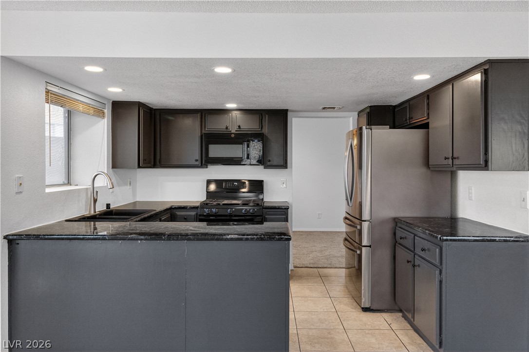 3156 Terrace View Drive Laughlin, NV 89029 - Photo 12 of 94 A well-appointed kitchen features dark cabinetry, granite countertops, and modern stainless steel appliances.