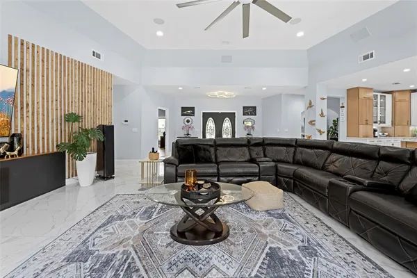a kitchen with stainless steel appliances kitchen island granite countertop a table chairs and a refrigerator