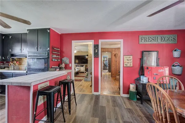 a kitchen with stainless steel appliances dining table a chair and a refrigerator