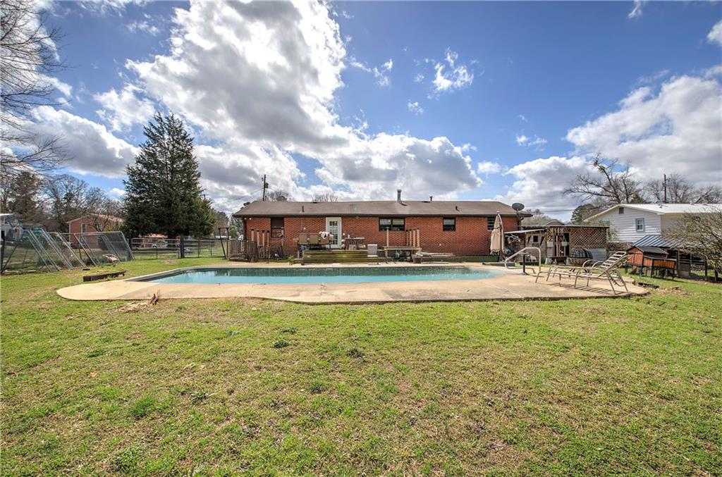 29 Johns Drive Northeast Rome, GA 30165 - Photo 22 of 26 a view of a swimming pool with a table and chairs under an umbrella