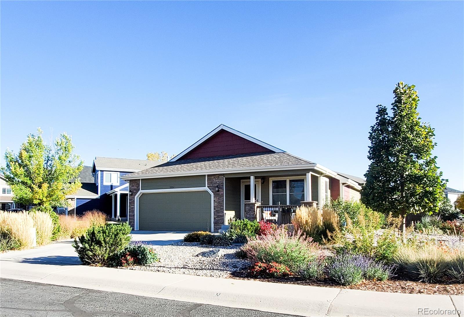 a front view of a house with a yard and potted plants