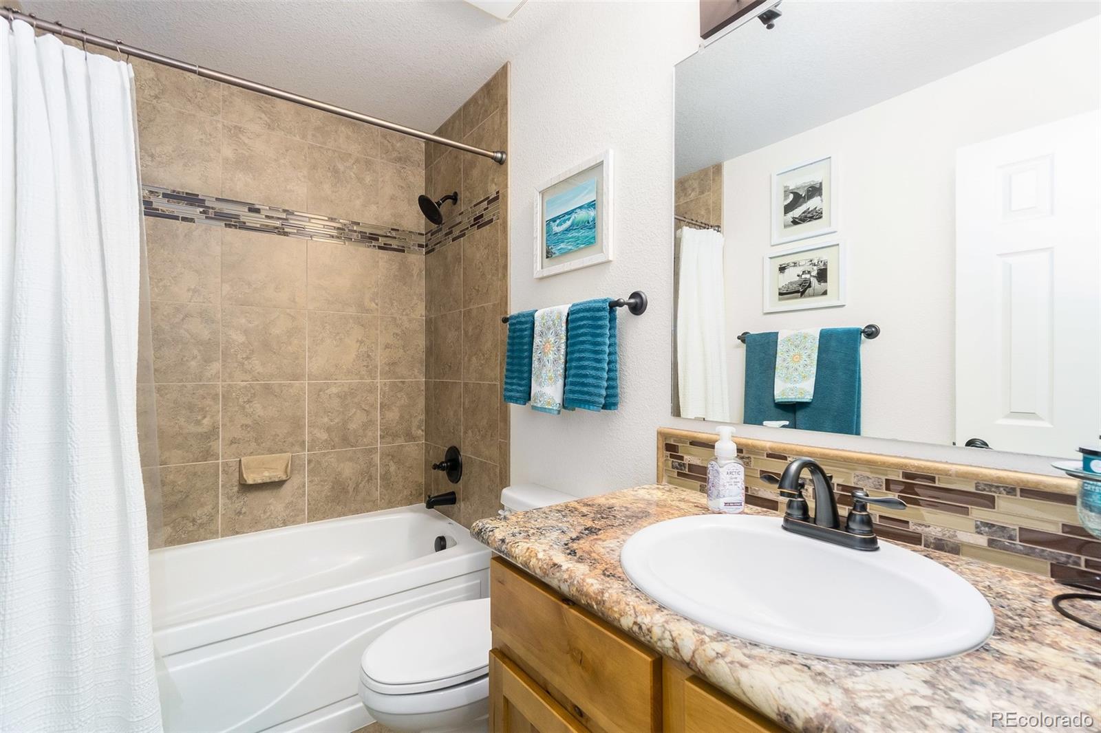 2151 Redhead Drive Johnstown, CO 80534 - Photo 25 of 37 a bathroom with a granite countertop sink toilet mirror and shower