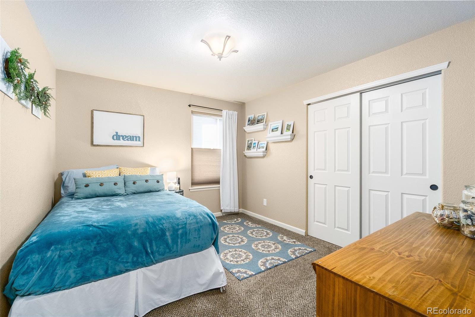 2151 Redhead Drive Johnstown, CO 80534 - Photo 26 of 37 a bedroom with a bed and a chandelier