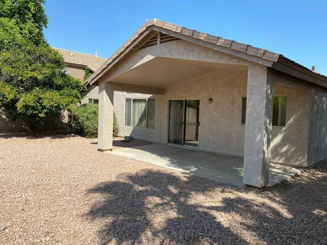 a view of an empty room with wooden floor and a mirror