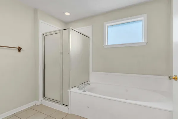 a white bath tub sitting next to a shower