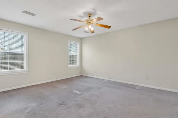 an empty room with a window and a fan