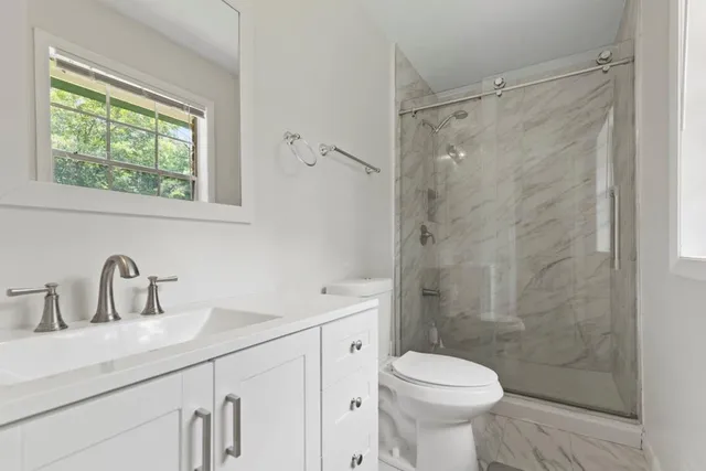 a bathroom with a sink toilet and shower