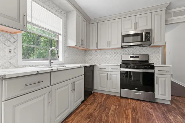 a kitchen with a sink stove and microwave