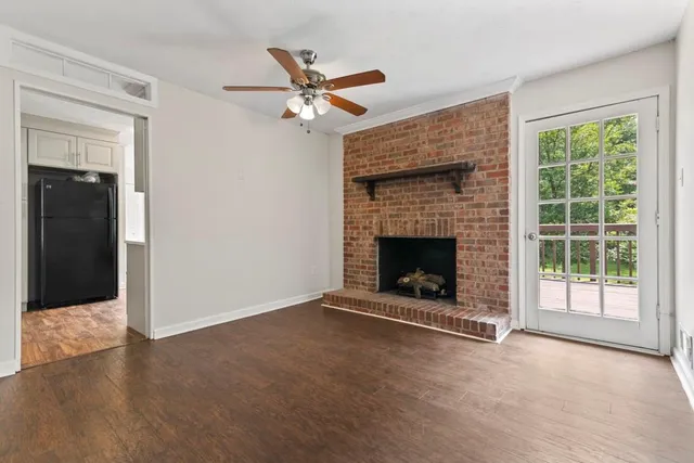 a view of an empty room with window and fire place