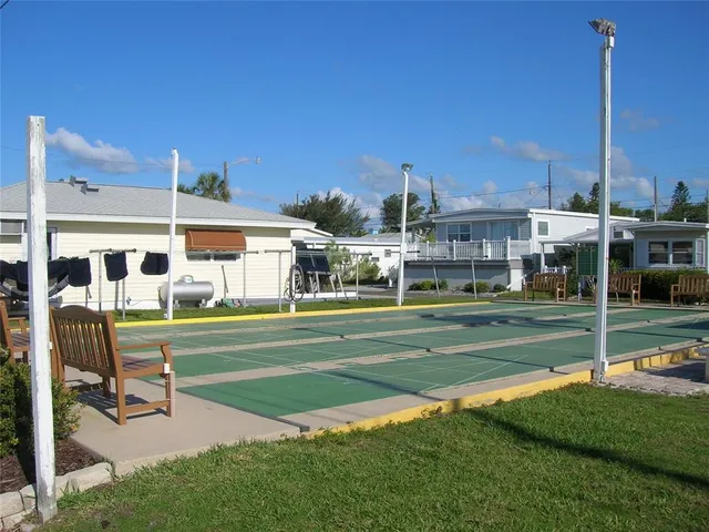 a view of pool with lawn chairs and a big yard