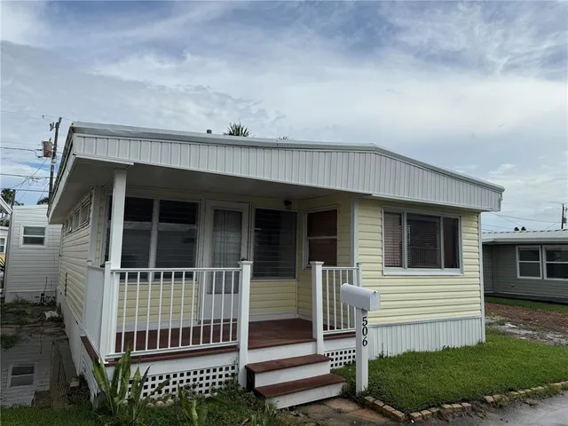 a view of a house with a small yard and wooden fence