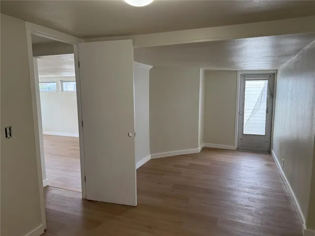 an empty room with wooden floor & closet area