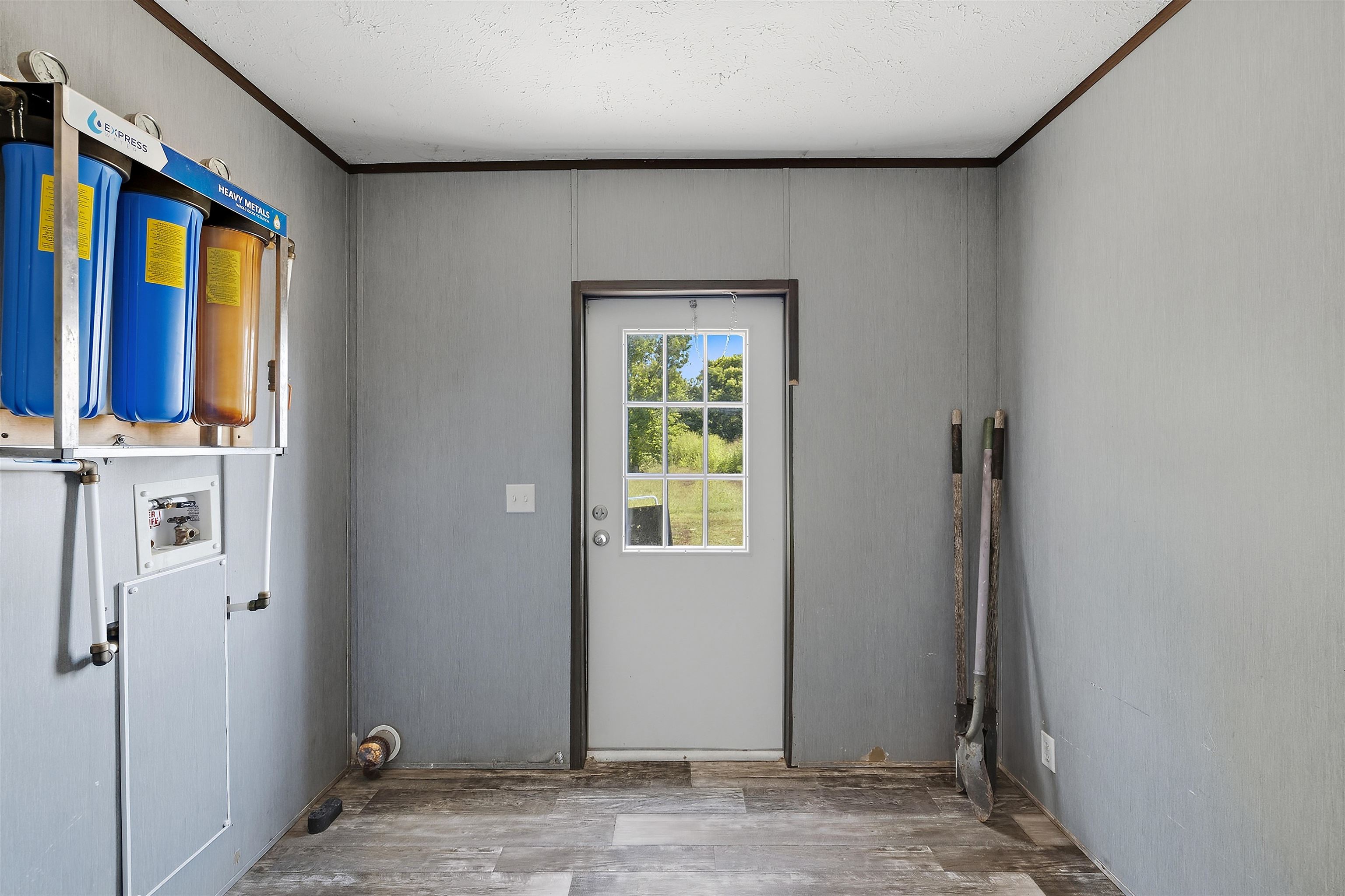 664 Rialto Road Covington, TN 38019 - Photo 14 of 24 Water filtration system, paneled walls, exterior door with window, and wood-finish flooring