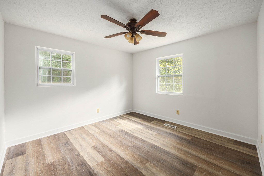 246 Sunnyside Church Road Pine Mountain, GA 31822 - Photo 12 of 26 an empty room with wooden floor and ceiling fan