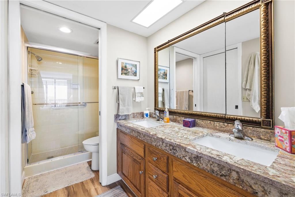 11 Bluebill Avenue, Unit 702 Naples, FL 34108 - Photo 15 of 35 a bathroom with a granite countertop sink toilet and shower