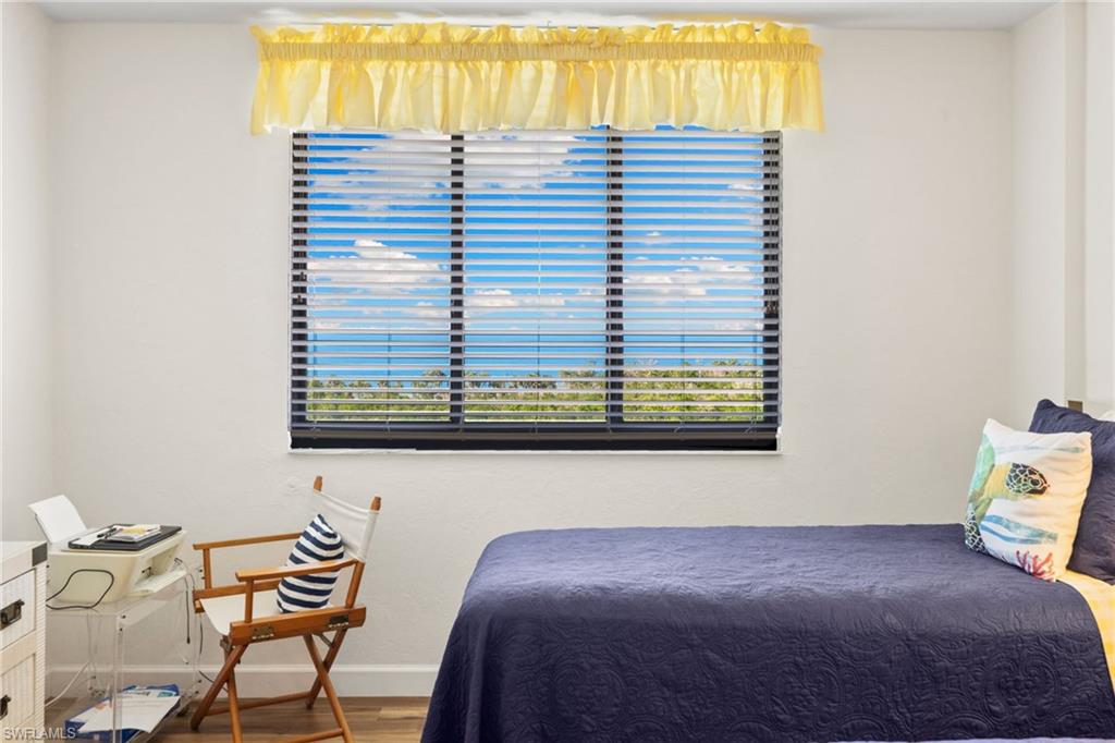 11 Bluebill Avenue, Unit 702 Naples, FL 34108 - Photo 19 of 35 a bedroom with a bed and a window