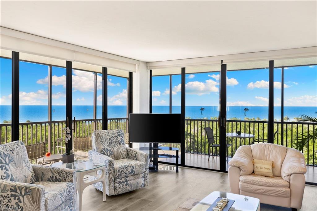 11 Bluebill Avenue, Unit 702 Naples, FL 34108 - Photo 3 of 35 a living room with furniture tv and a large window
