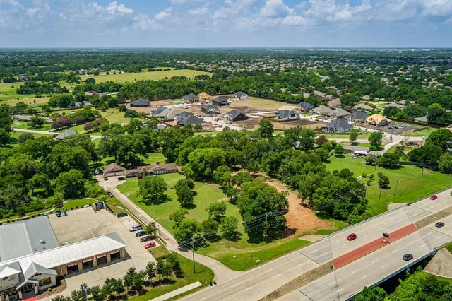 an aerial view of residential houses with outdoor space and trees