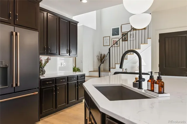 a kitchen with kitchen island stainless steel appliances a sink a stove and a refrigerator