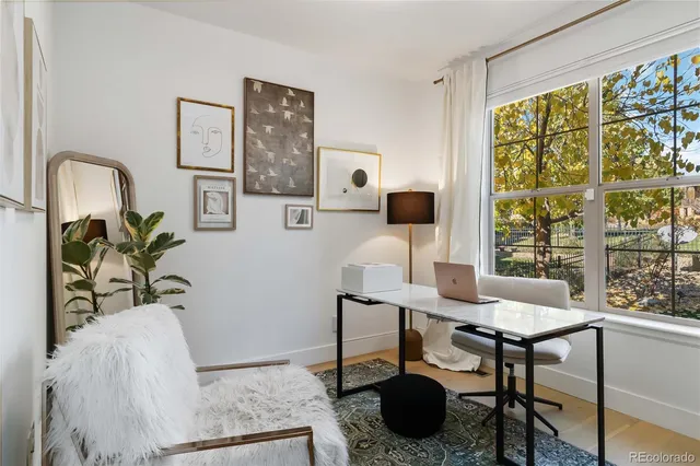 a view of a workspace with furniture and a window