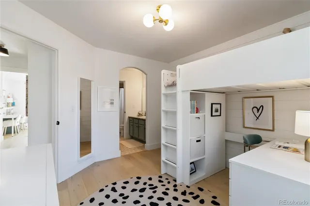 a bedroom with a dresser and a view of bathroom