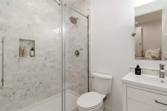 a bathroom with a toilet sink vanity and shower