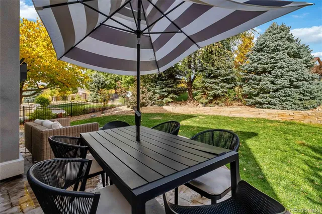 a view of a backyard with table and chairs under an umbrella