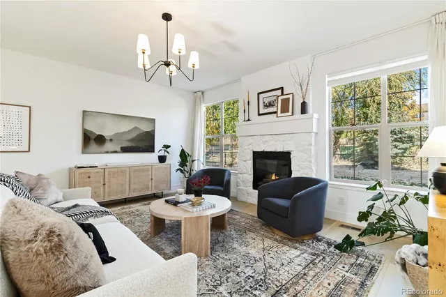 a living room with furniture a chandelier and a flat screen tv