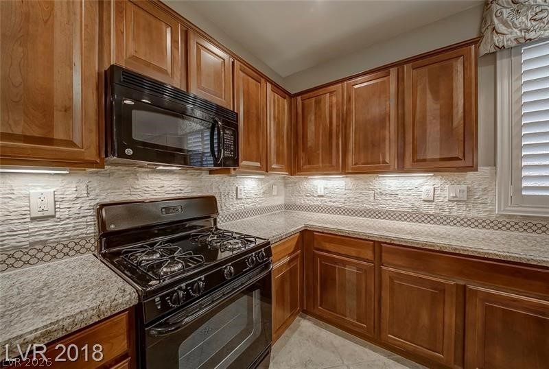 3144 Whitfeild Avenue Henderson, NV 89044 - Photo 11 of 55 Culinary delights await in this well-appointed kitchen, featuring a gas range and plentiful cabinetry.