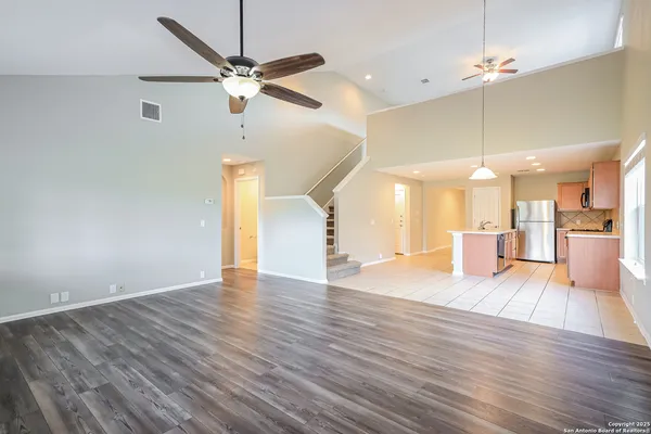 a view of empty room with wooden floor and ceiling fan