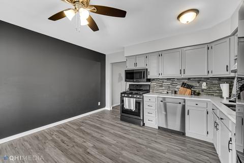 249 Rockhurst Road Bolingbrook, IL 60440 - Photo 6 of 18 a kitchen with stainless steel appliances a stove top oven a sink and white cabinets