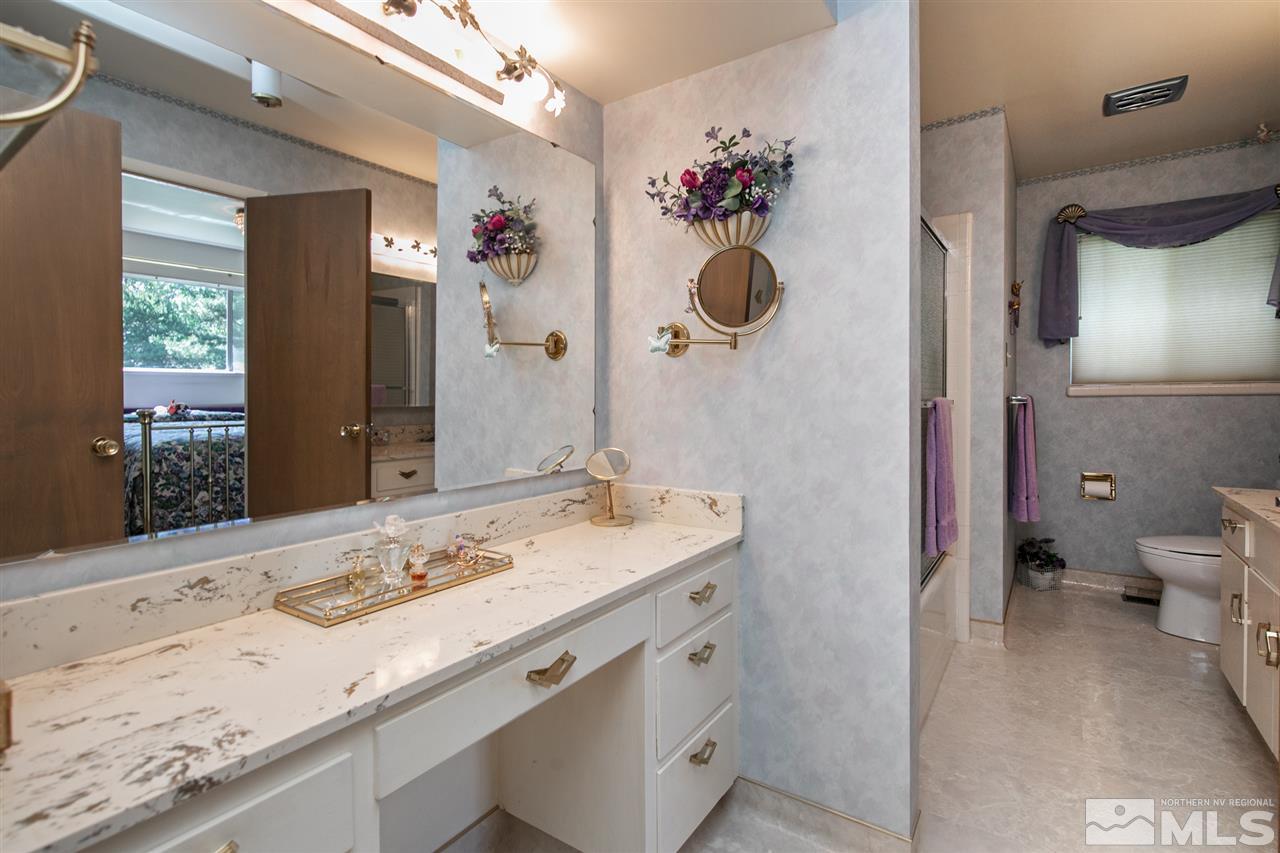 3360 Marthiam Avenue Reno, NV 89509 - Photo 20 of 39 a bathroom with a granite countertop sink a toilet and shower
