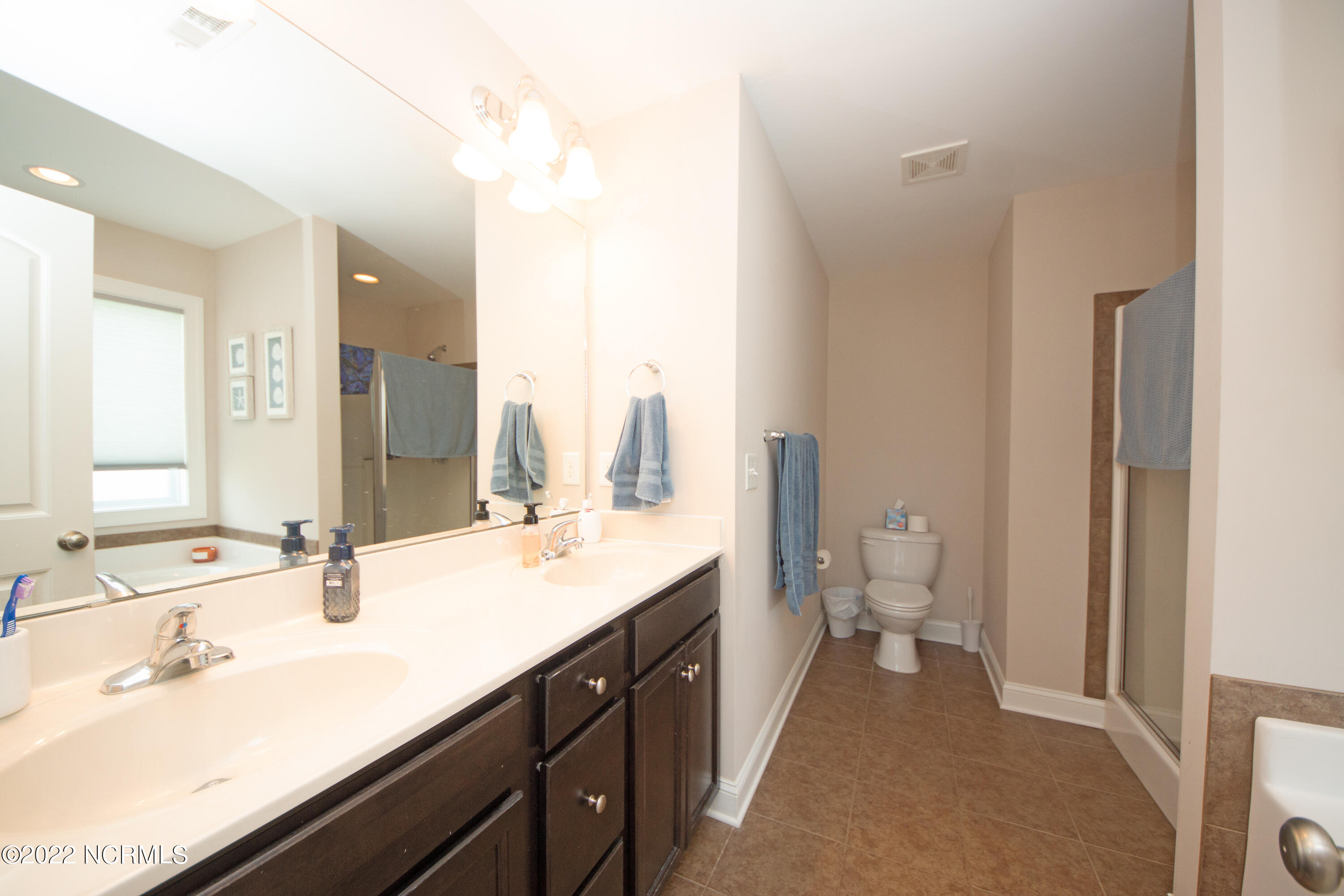 309 Catamaran Road Swansboro, NC 28584 - Photo 28 of 68 Primary bathroom with double sinks, soaking tub, and walk-in shower