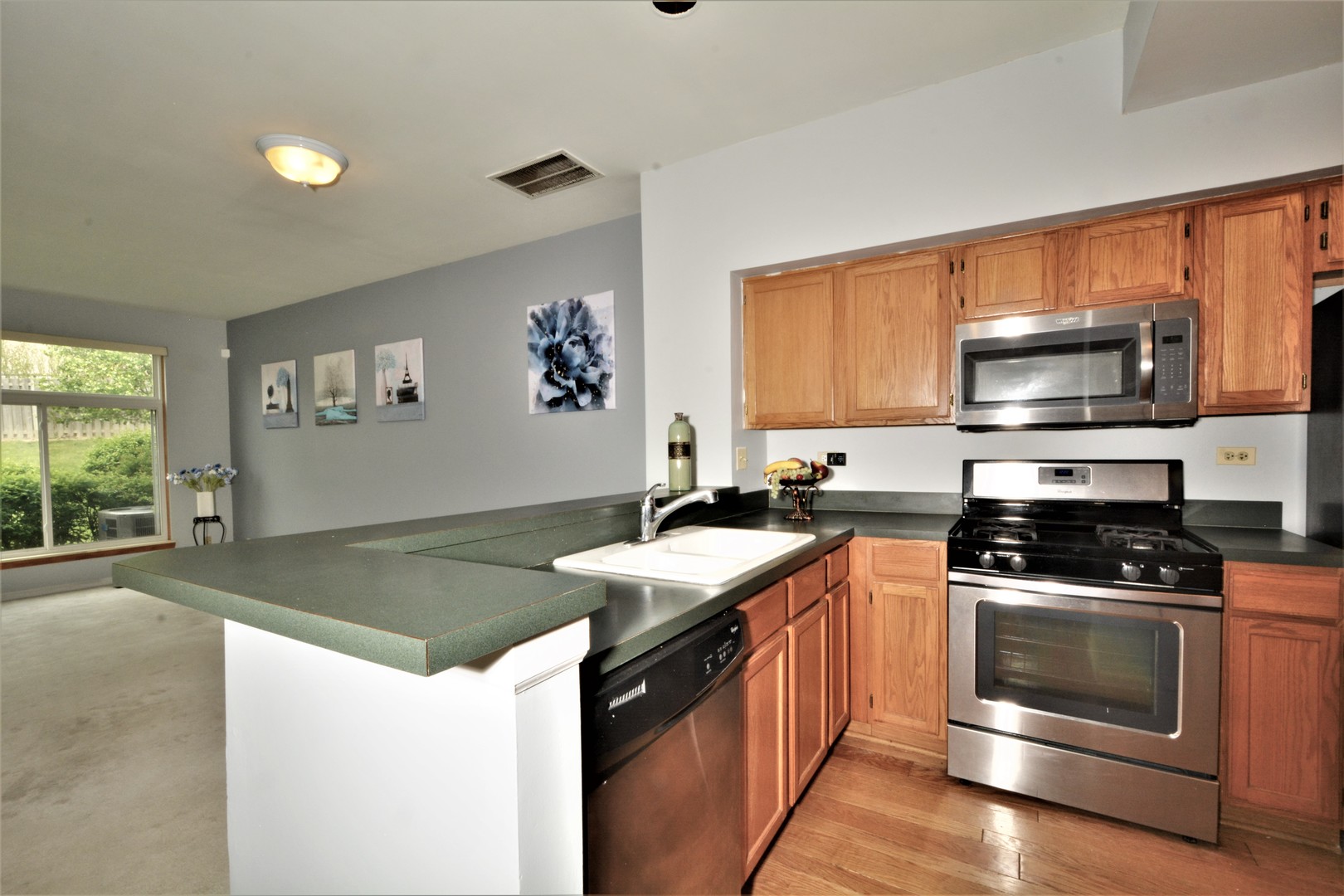 8187 Ripple Ridge Darien, IL 60561 - Photo 2 of 21 a kitchen with stainless steel appliances granite countertop a stove a sink and a microwave