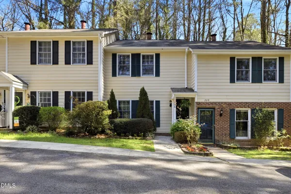a front view of a house with a yard and potted plants