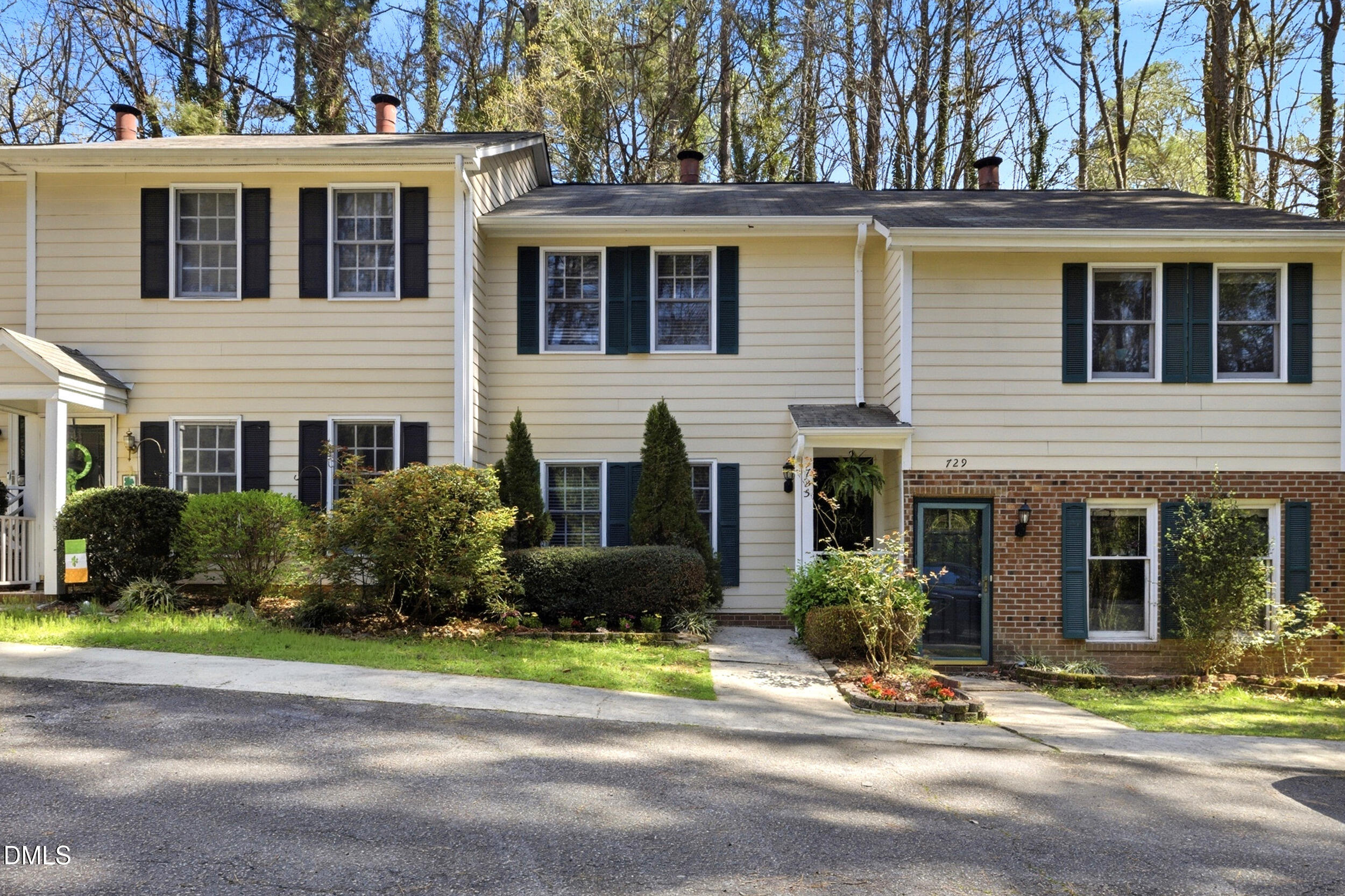 a front view of a house with a yard and potted plants