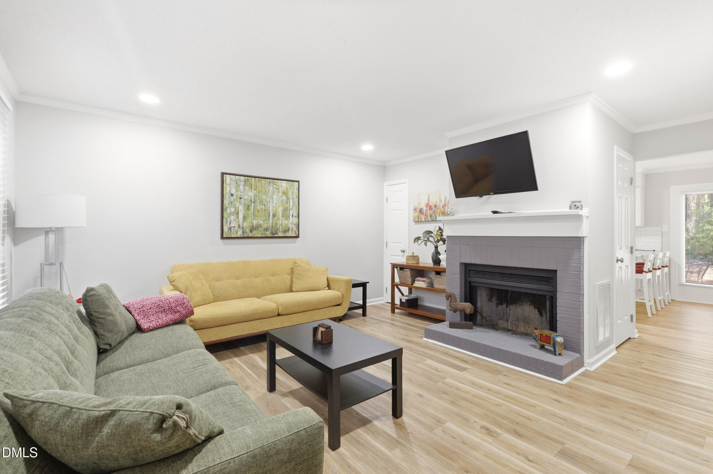 725 Charleston Road Raleigh, NC 27606 - Photo 3 of 27 a living room with furniture a flat screen tv and a fireplace