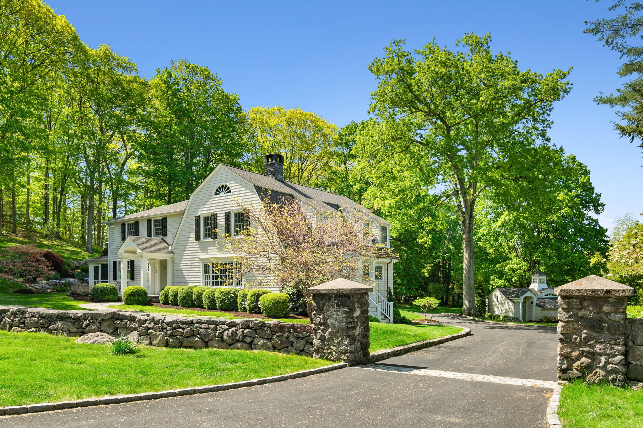 1466 Ponus Ridge Road New Canaan, CT 06840 - Photo 3 of 81 a front view of a house with a garden