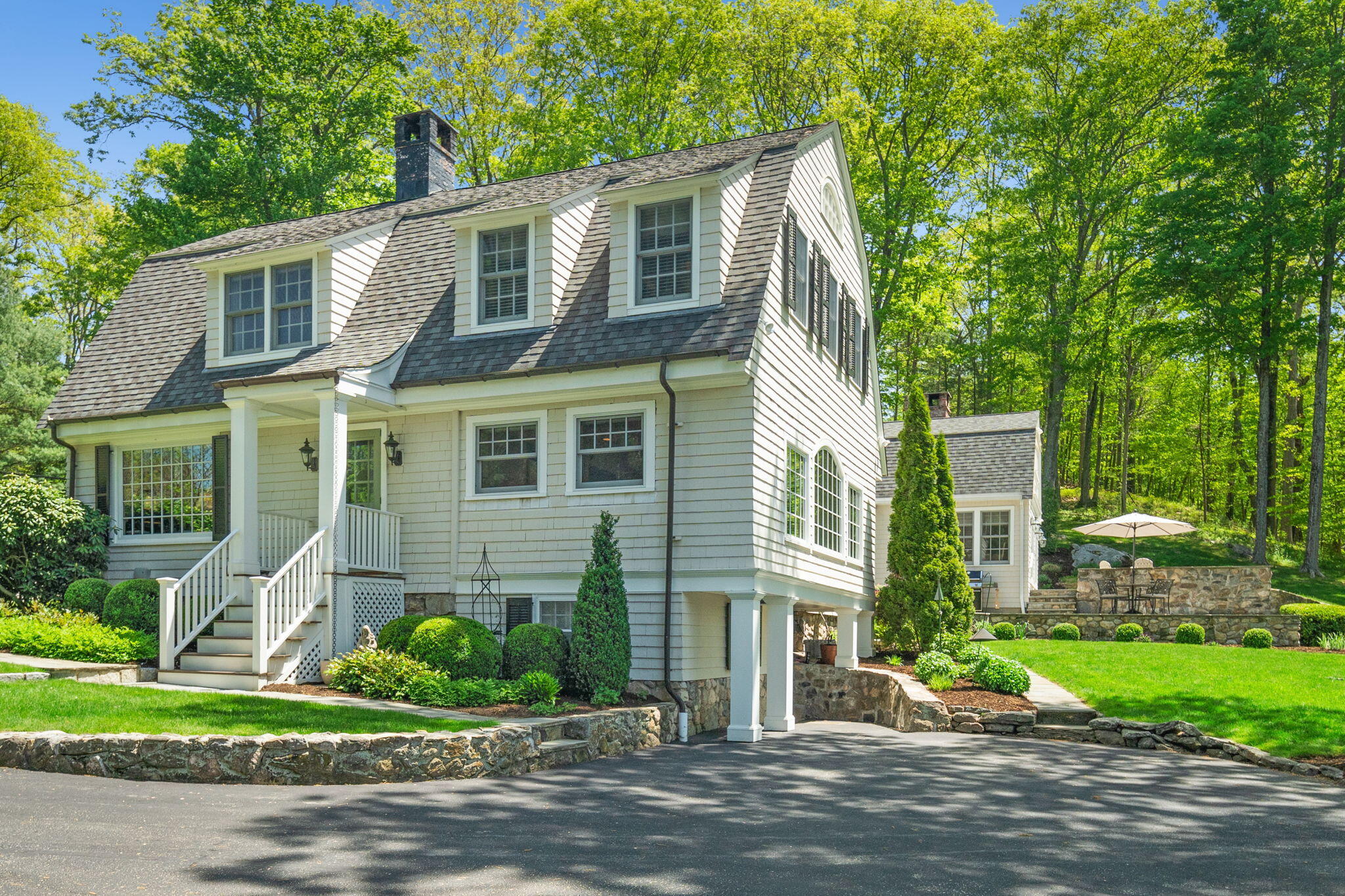 1466 Ponus Ridge Road New Canaan, CT 06840 - Photo 53 of 81 a front view of a house with a yard and potted plants