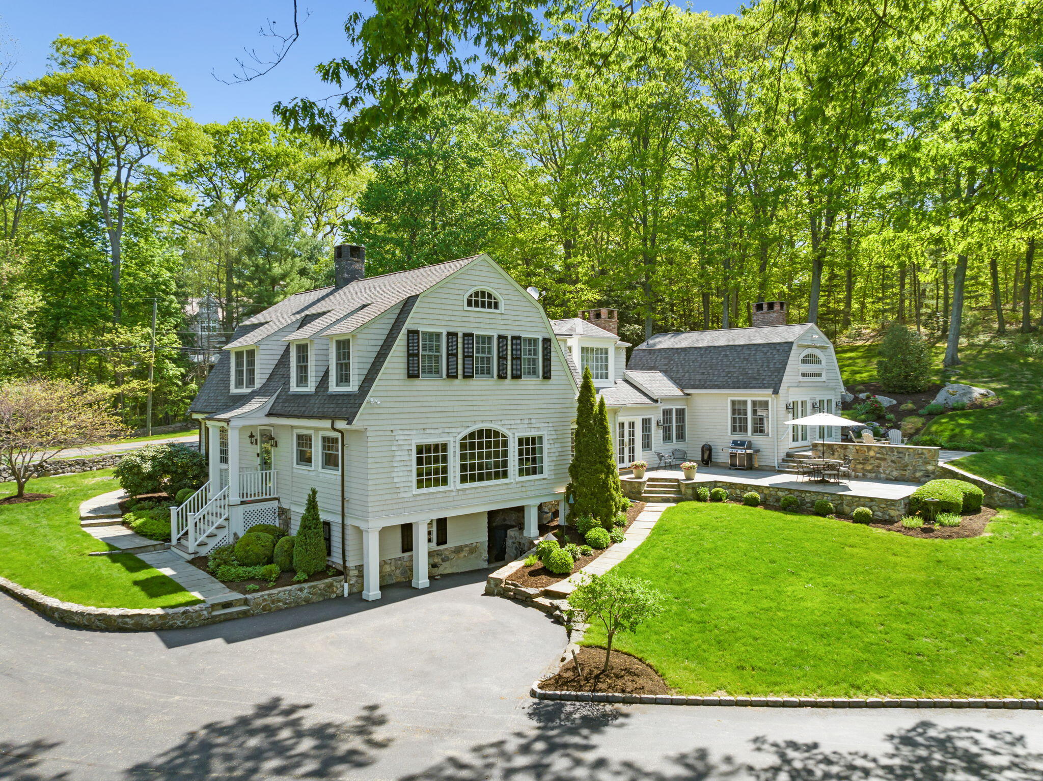 1466 Ponus Ridge Road New Canaan, CT 06840 - Photo 56 of 81 a front view of a house with a yard table and chairs