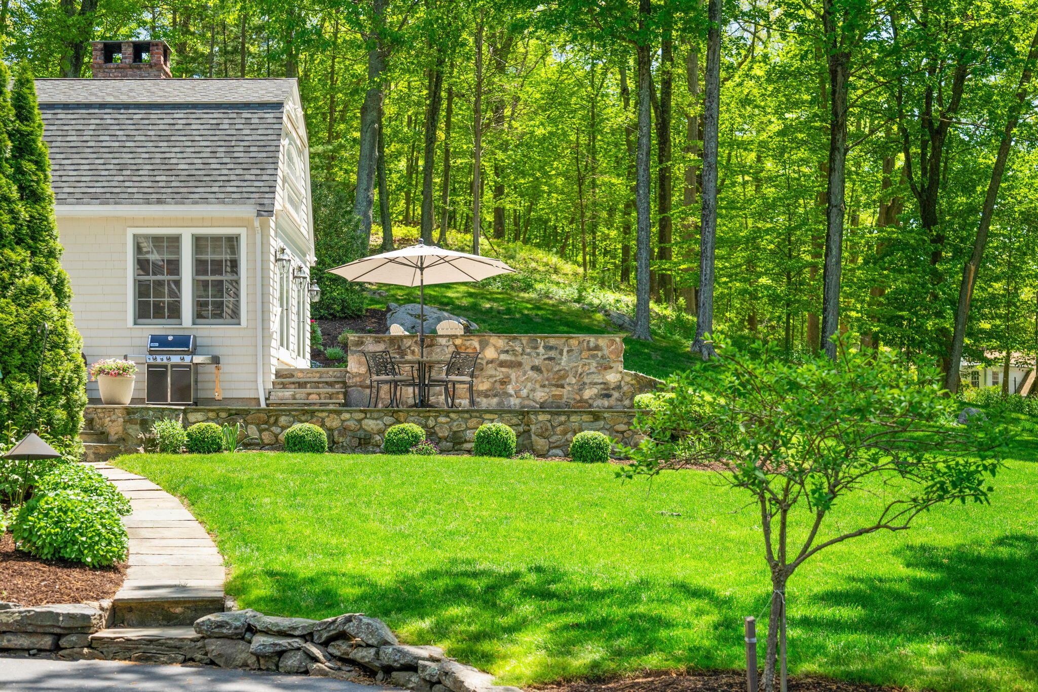 1466 Ponus Ridge Road New Canaan, CT 06840 - Photo 66 of 81 a view of a backyard with table and chairs under an umbrella