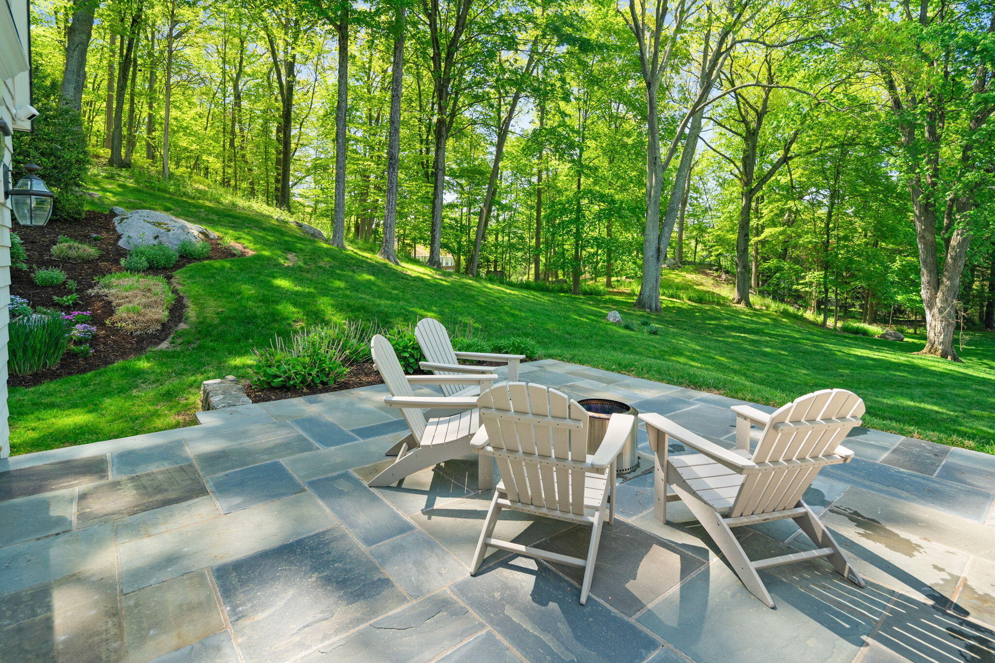 1466 Ponus Ridge Road New Canaan, CT 06840 - Photo 71 of 81 a view of a chairs and table in backyard of the house