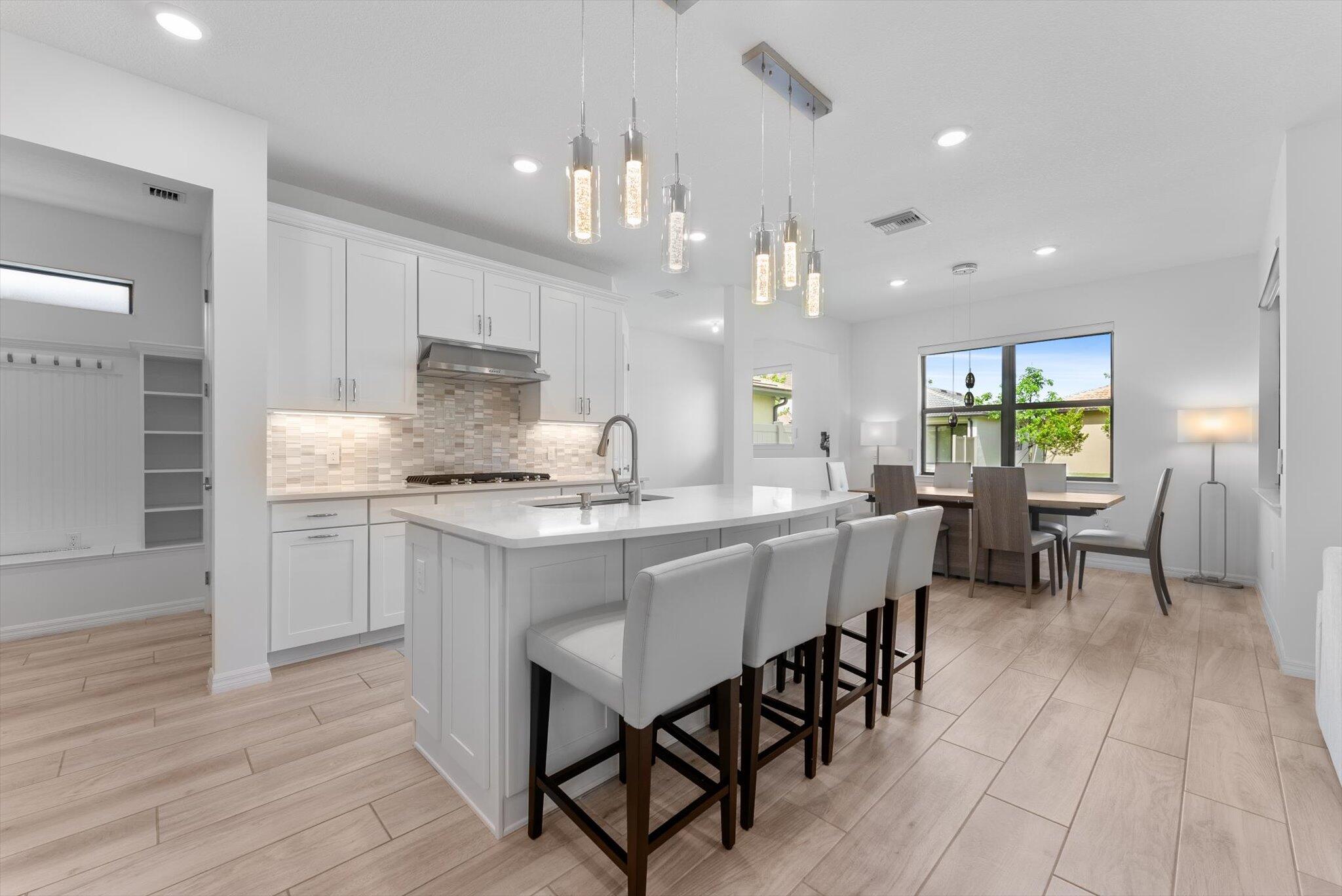 4757 Roldan Court, Unit ROLDAN CT Lake Worth, FL 33467 - Photo 5 of 37 a kitchen with kitchen island granite countertop a table chairs sink and cabinets