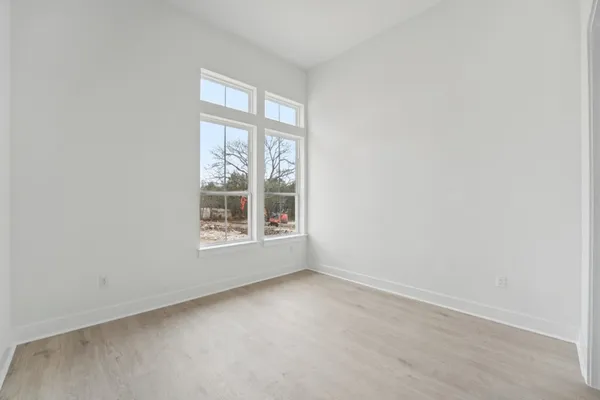 a view of an empty walk in closet with wooden floor