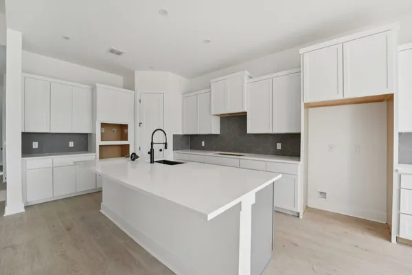 a view of a refrigerator in kitchen and white cabinets