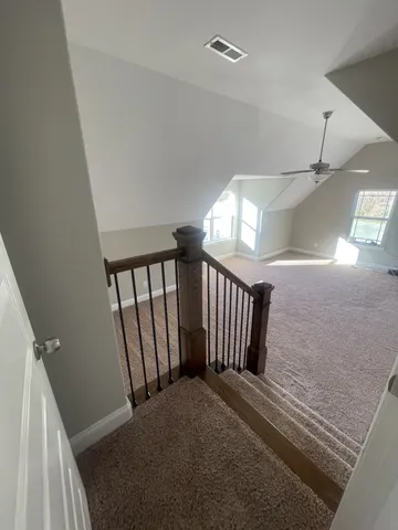 a view of staircase with white walls and a window