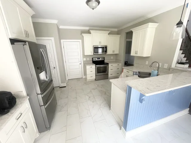 a kitchen with a sink a microwave a refrigerator and cabinets