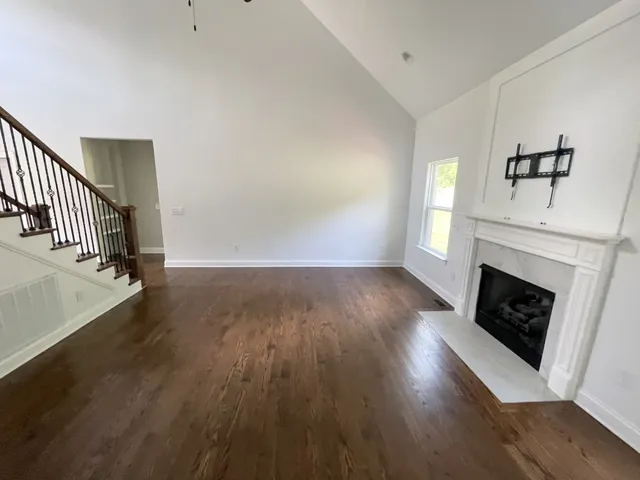 a view of a livingroom with wooden floor and a fireplace